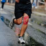Kinesiotaping w sporcie - biegacz z różowymi plastrami na kolanie