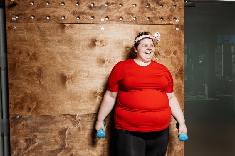uśmiechnięta otyła kobieta na siłowni