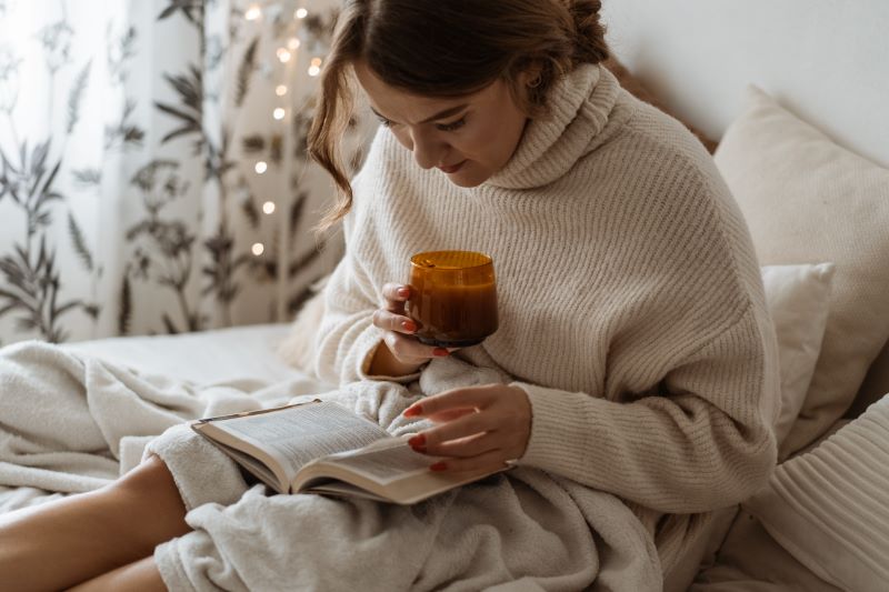 kobieta czytająca ksiązkę w łóżku